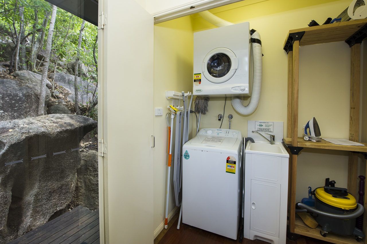 Ein kleiner Hauswirtschaftsraum mit Waschmaschine, Trockner und Bügelecke.