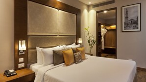A hotel room with a large bed, bedside lamps, a telephone, and a framed picture on the wall. - Lemon Tree Hotel, Sector 68, Sohna Road, Gurugram (Gurugram)