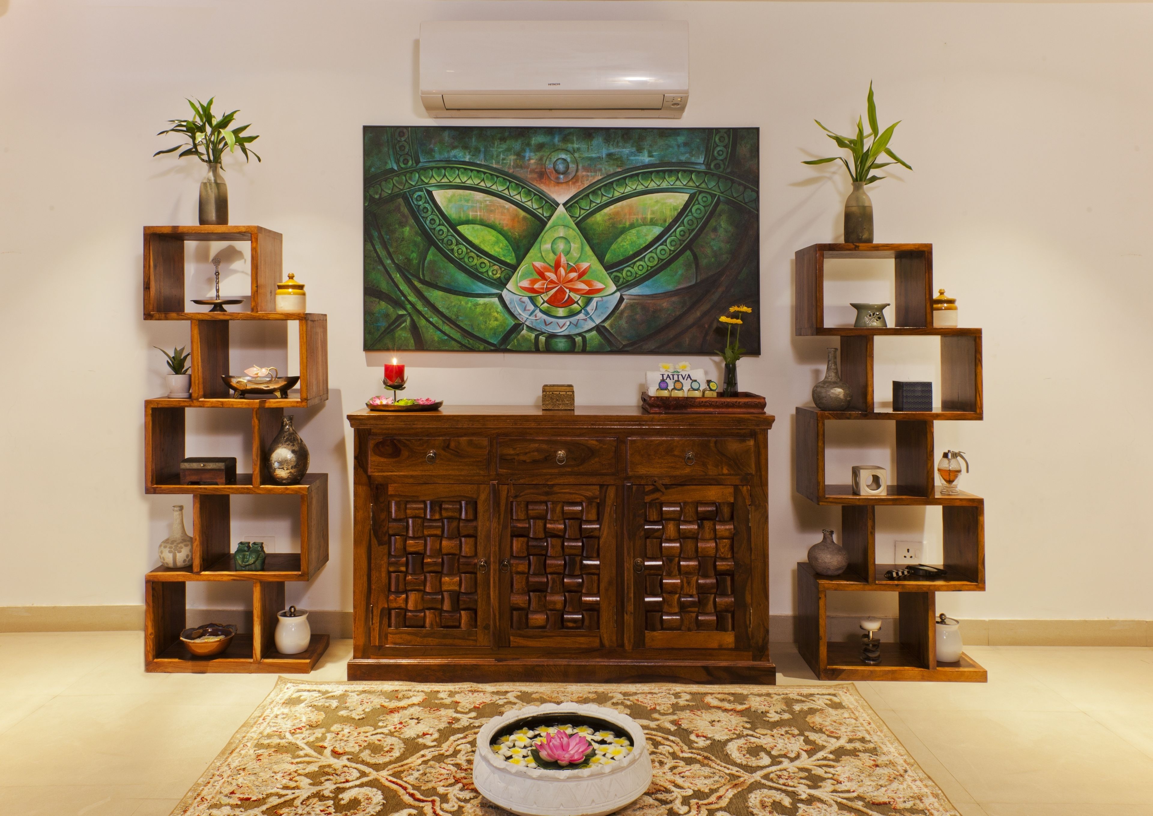 A living room with a wooden cabinet, shelves with decorative items, a painting, and a floral arrangement on the floor.