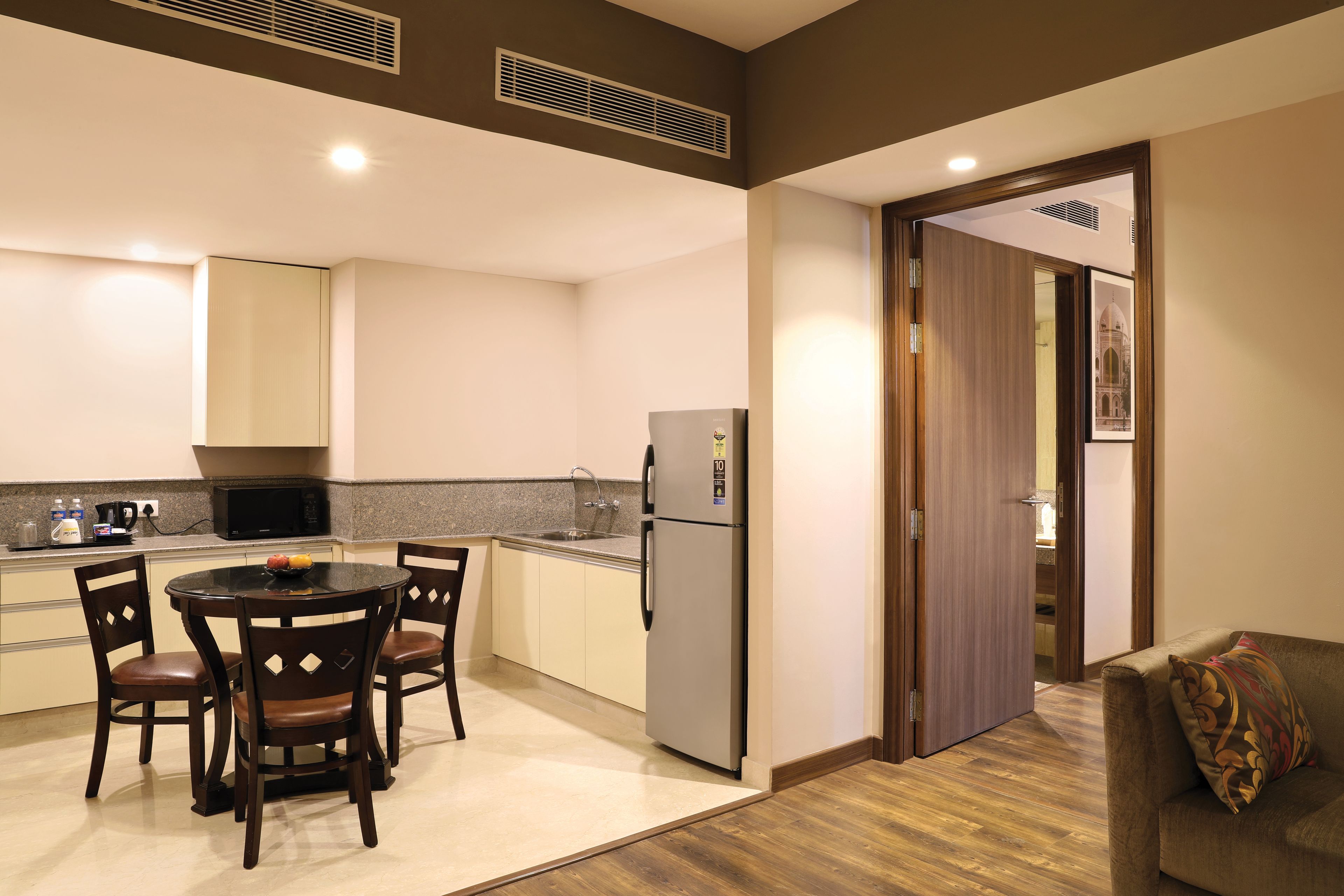 A modern kitchen with a dining area, a refrigerator, and a microwave.