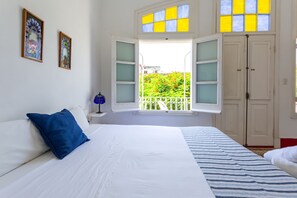 Relax in a serene room with a large bed, garden views, and a minimalist design.