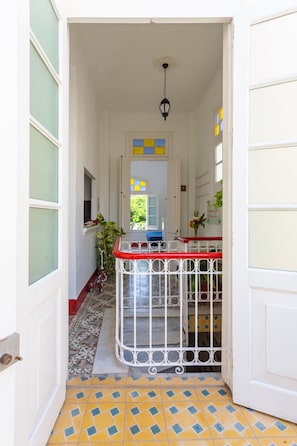 Stylish hallway leads to a room with a geometric tile floor and a door with frosted glass panels.