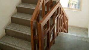A staircase with wooden railings and a view of the outside through a window.