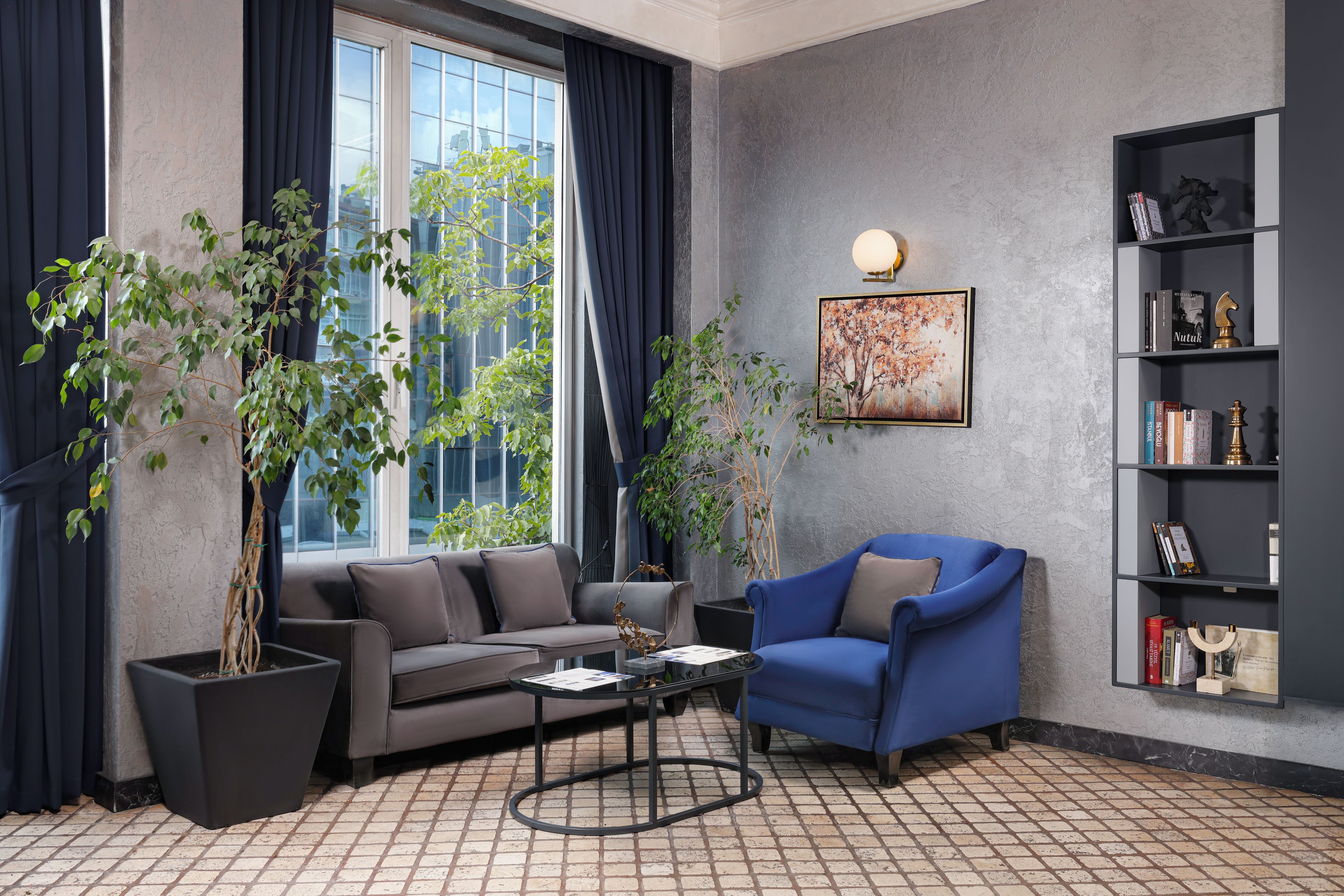 En moderne stue med sofa, lænestol, sofabord og reol.