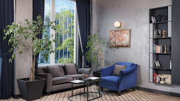 En moderne stue med sofa, lænestol, sofabord og reol.