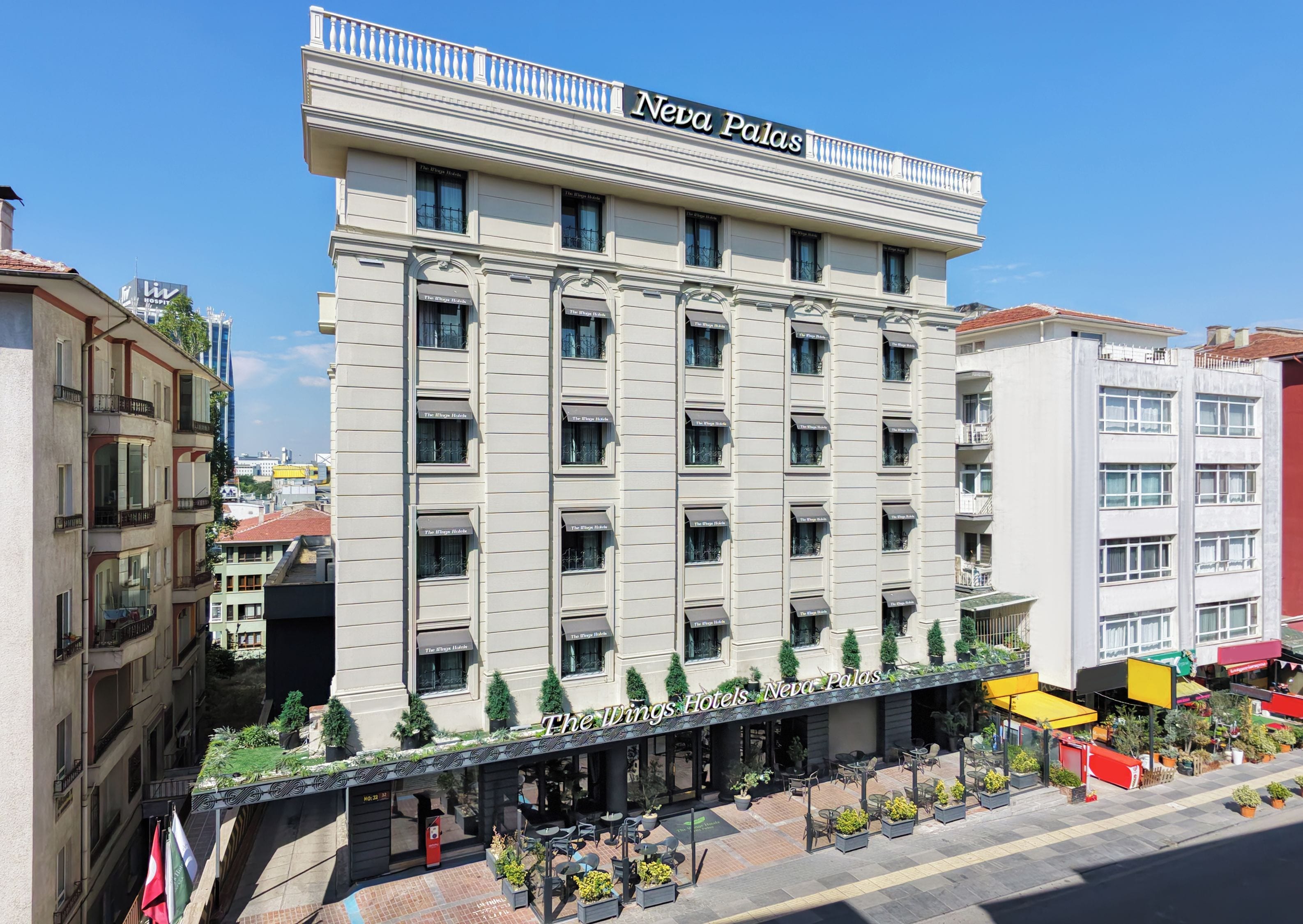 Un hôtel à plusieurs étages, doté de balcons et d’un restaurant situé au rez-de-chaussée.