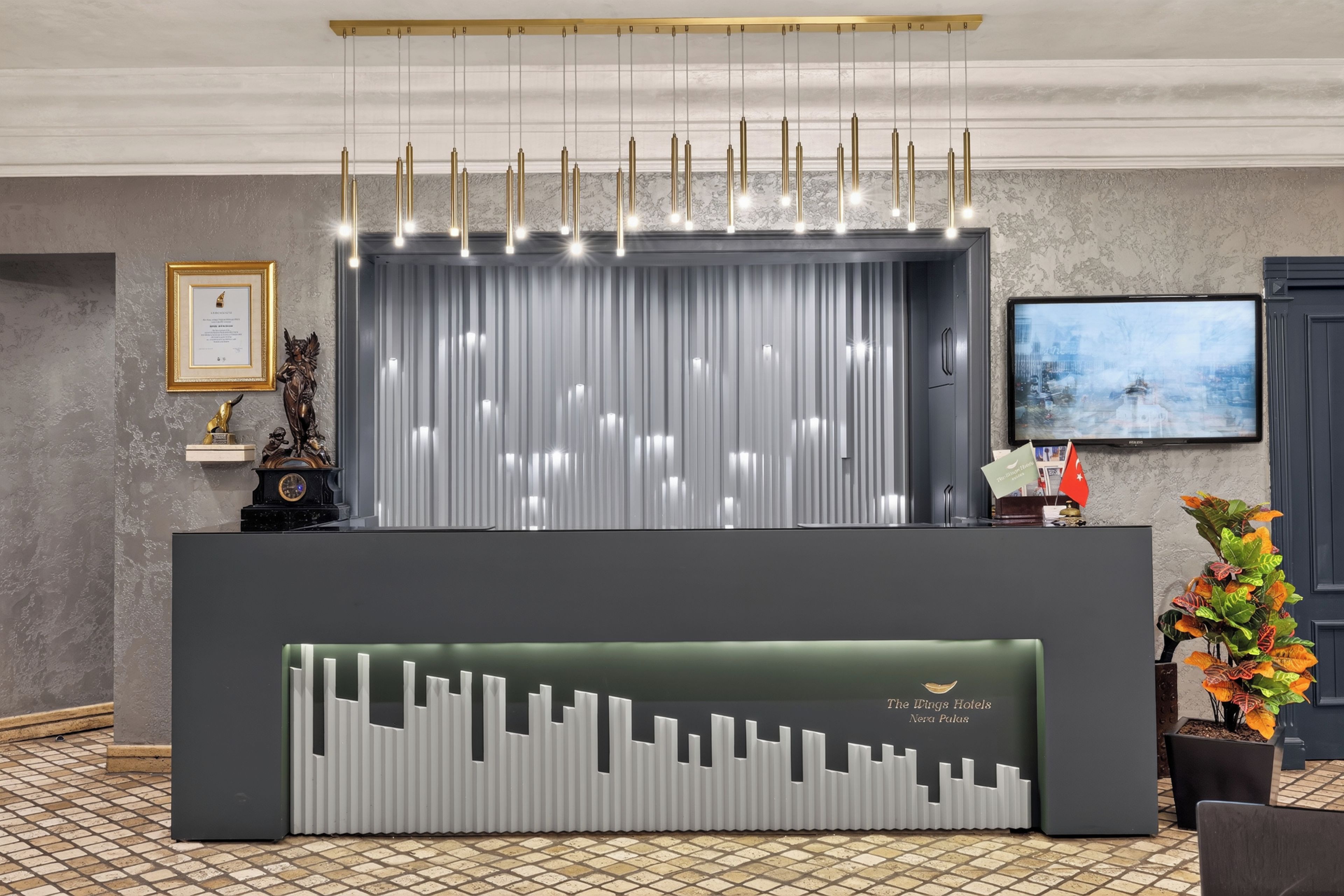 Un mostrador de recepción de diseño moderno, con una lámpara vertical y una pantalla digital.