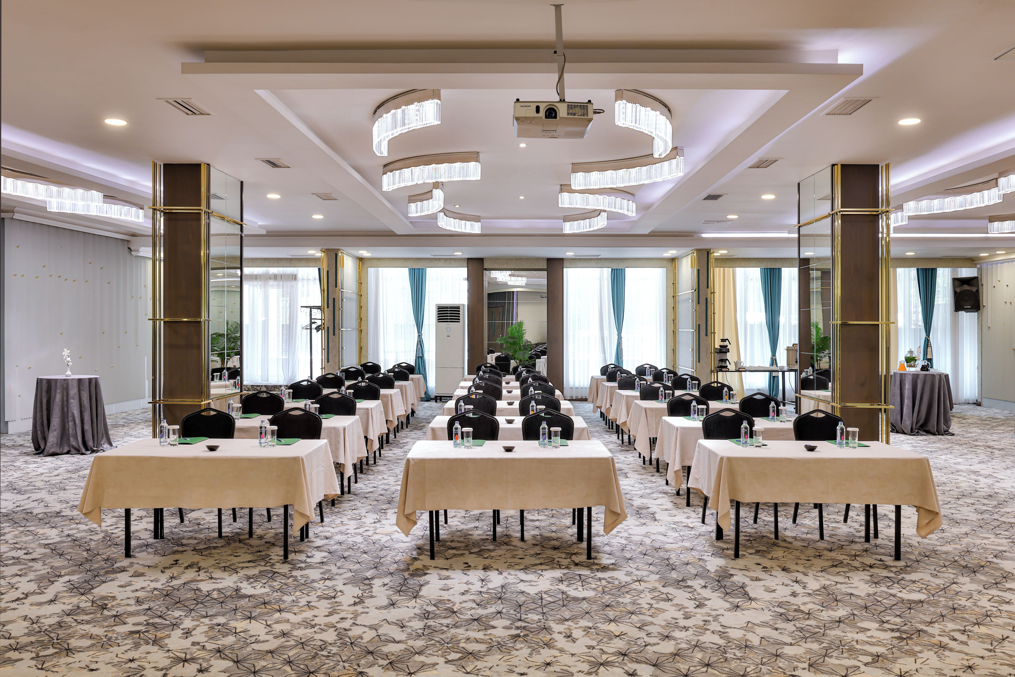 Un salón de conferencias con mesas y sillas dispuestas para una reunión.