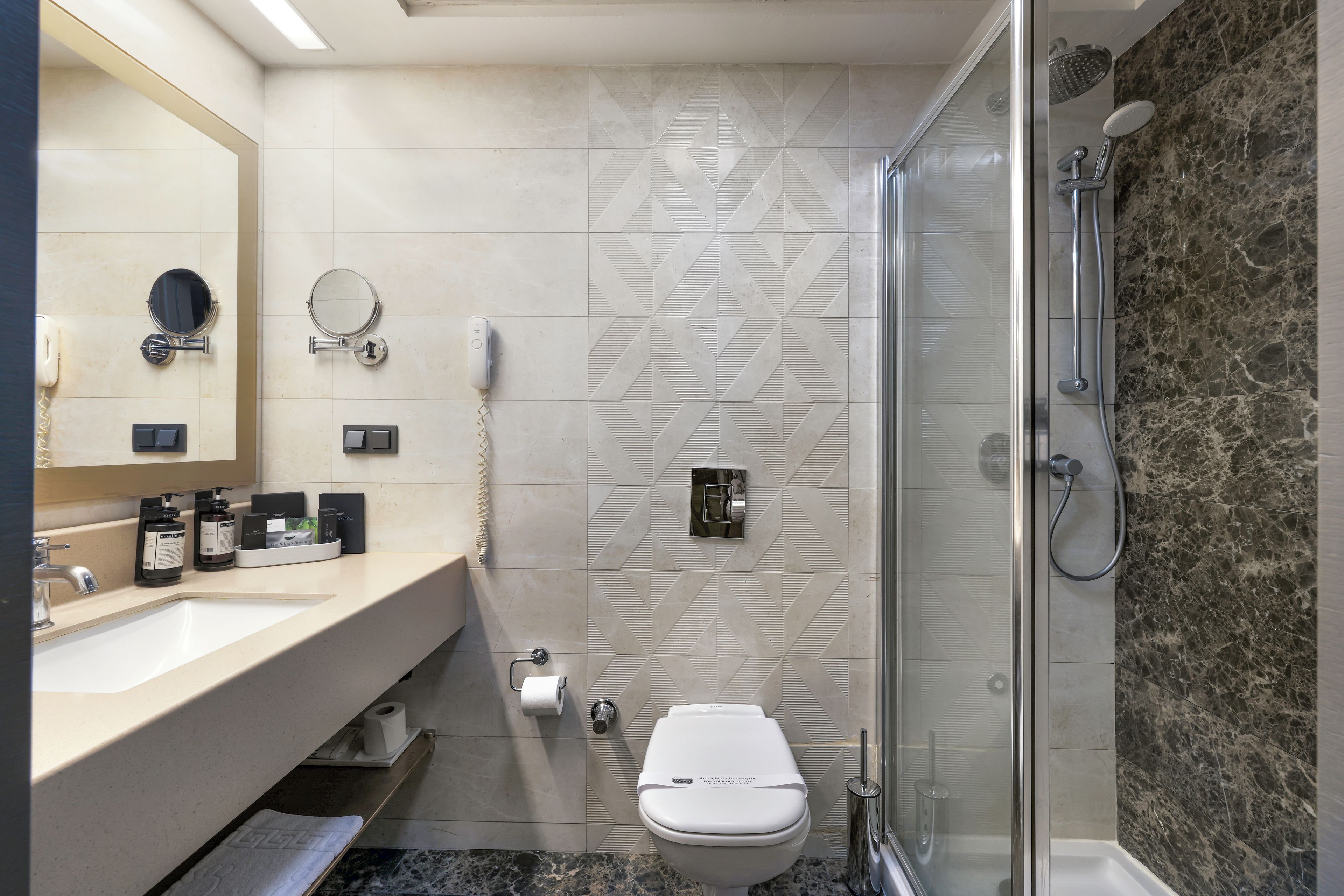 A modern bathroom with a shower, toilet, and vanity.