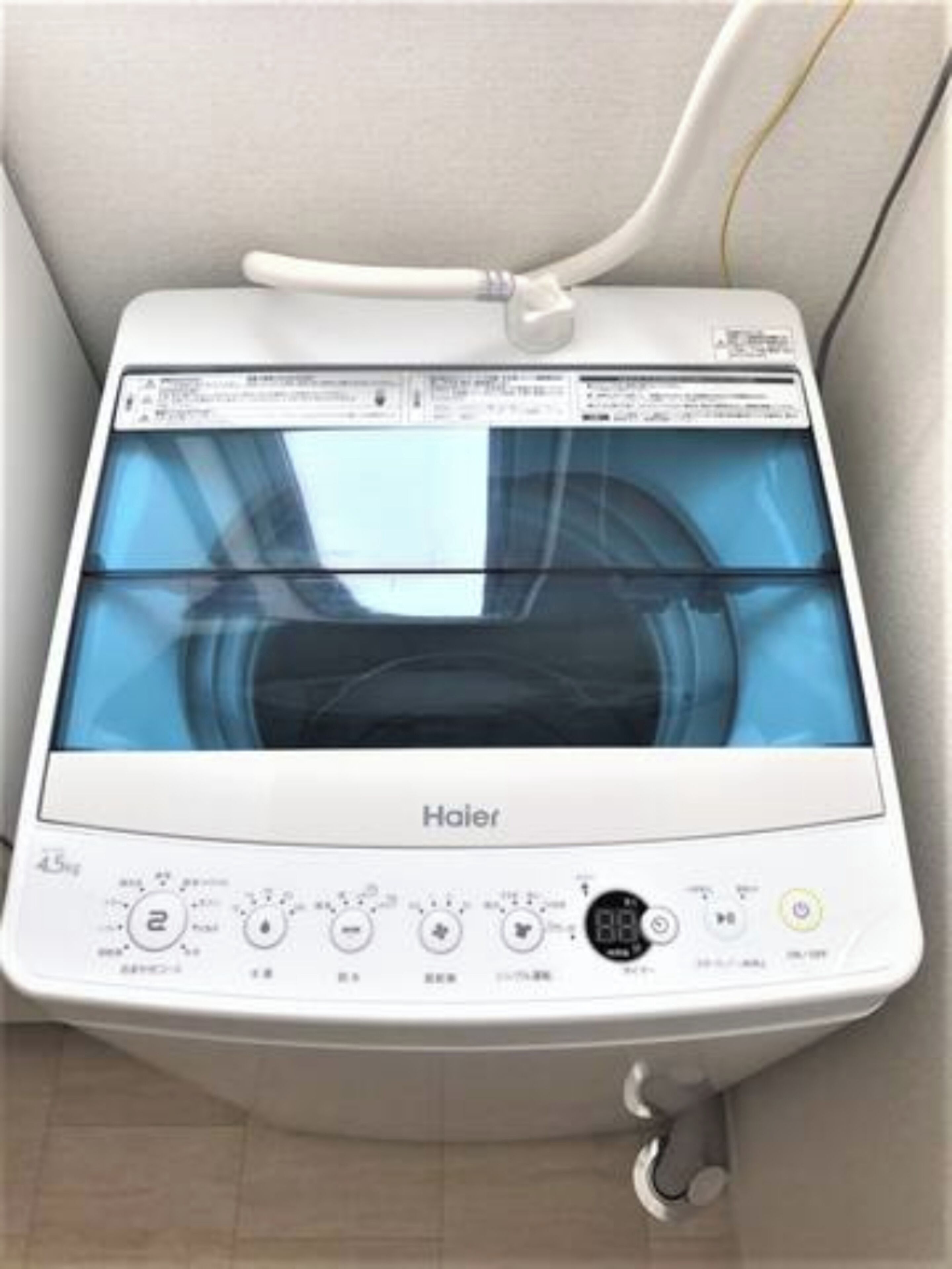 A Haier washing machine with a digital display and control panel, installed in a bathroom.
