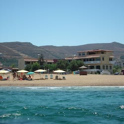 Na praia, espreguiçadeiras, guarda-sóis, toalhas de praia