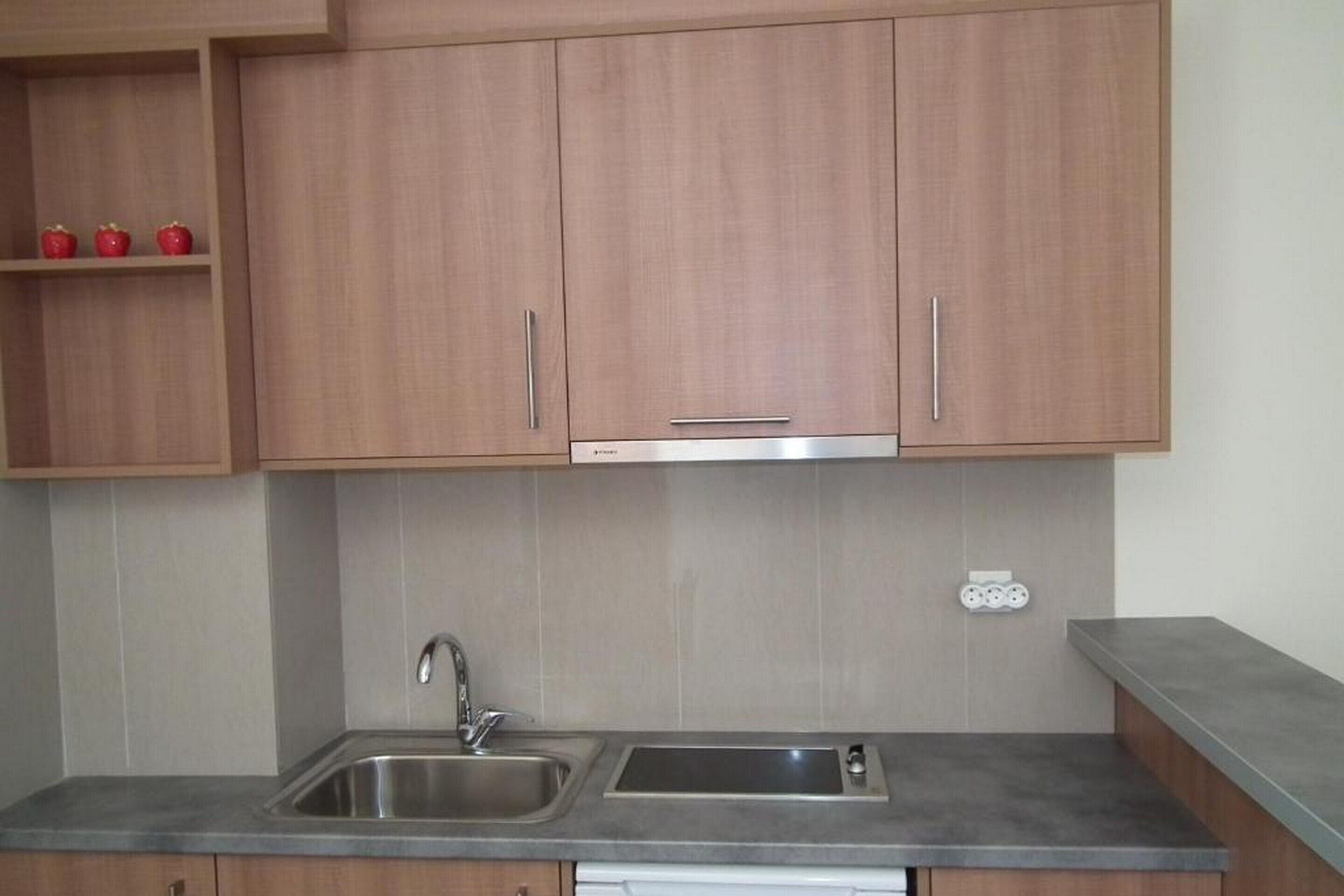 A kitchen with wooden cabinets, a stainless steel sink, and a dishwasher.