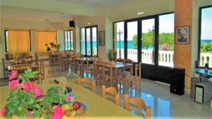 A dining area with a long table, chairs, and a view of the sea. - Gramvoussa Bay (Kissamos)
