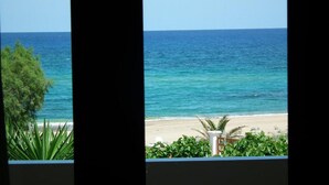 A view of a beach with clear blue water and a sandy shore, framed by greenery. - Gramvoussa Bay (Kissamos)