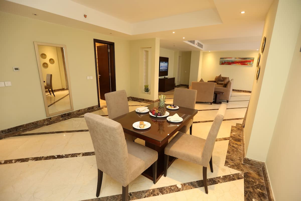A dining area with a marble floor, a wooden table, and four chairs.