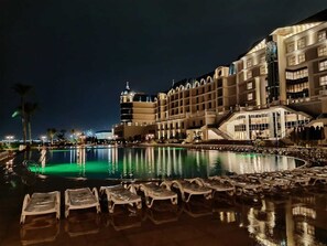 A hotel with a large pool, multiple floors, and a well-lit exterior. - Tolip El Forsan Hotel (Ismailia)