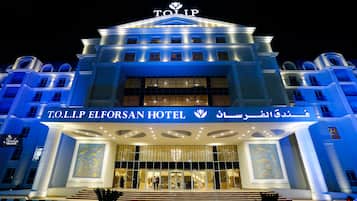 L’extérieur de l’hôtel TOLIP ELFORSAN se distingue par son entrée imposante et son enseigne lumineuse.