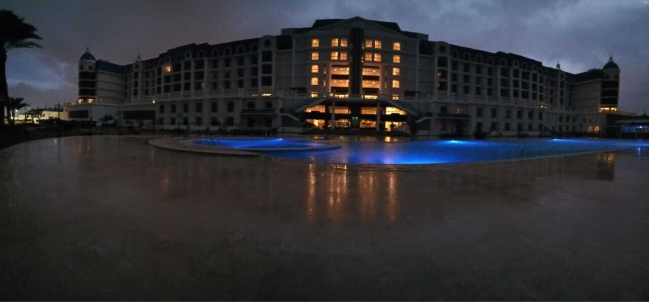 Un grande hotel con numerosi piani e un cortile centrale con piscina.