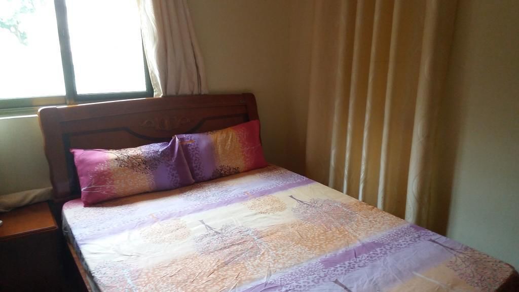 Un lit avec une couvre-lit à motifs et un seul oreiller.