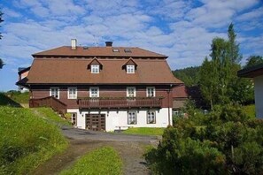 A large, two-story house with a sloped roof and a balcony.