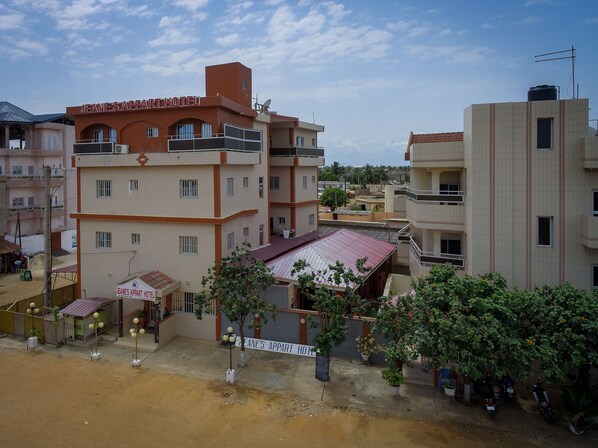 A hotel with multiple floors, a flat roof, and a sign indicating it is 'JEANE'S APPART HOTEL'.