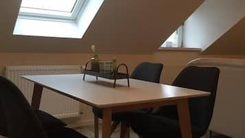 A dining area with a table and chairs, a skylight, and a radiator.