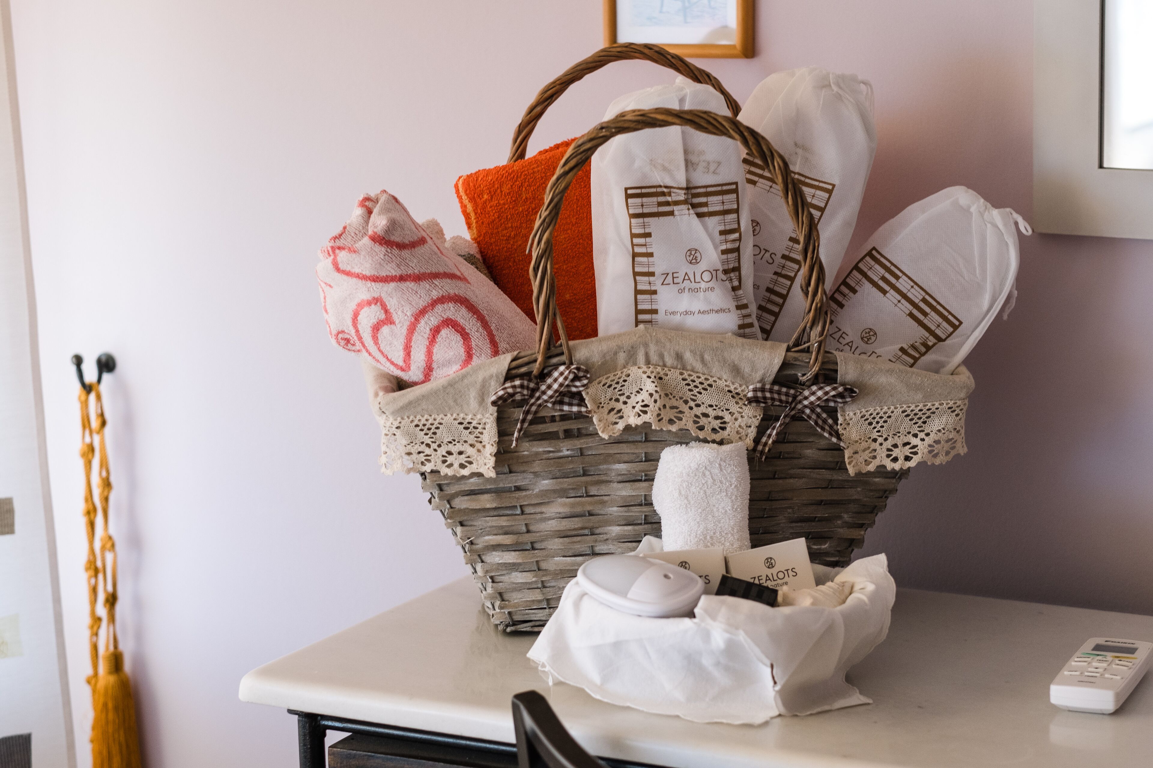 A wicker basket filled with bags and a remote control on a table.