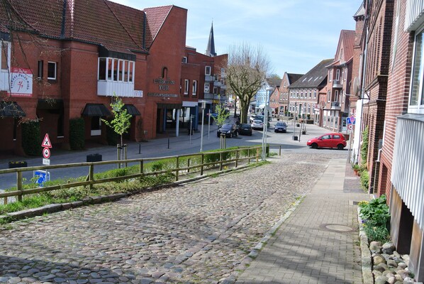 A cobblestone street lined with brick buildings, some with signage indicating shops and services. - Ferienwohnung Kruppa (Ploen)