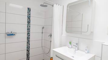A modern bathroom with a shower, a sink, and a mirror.
