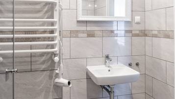 A bathroom with a white sink, a mirror, and a towel rack.