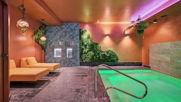 Un espacio de spa con piscina, asientos y paredes decorativas.