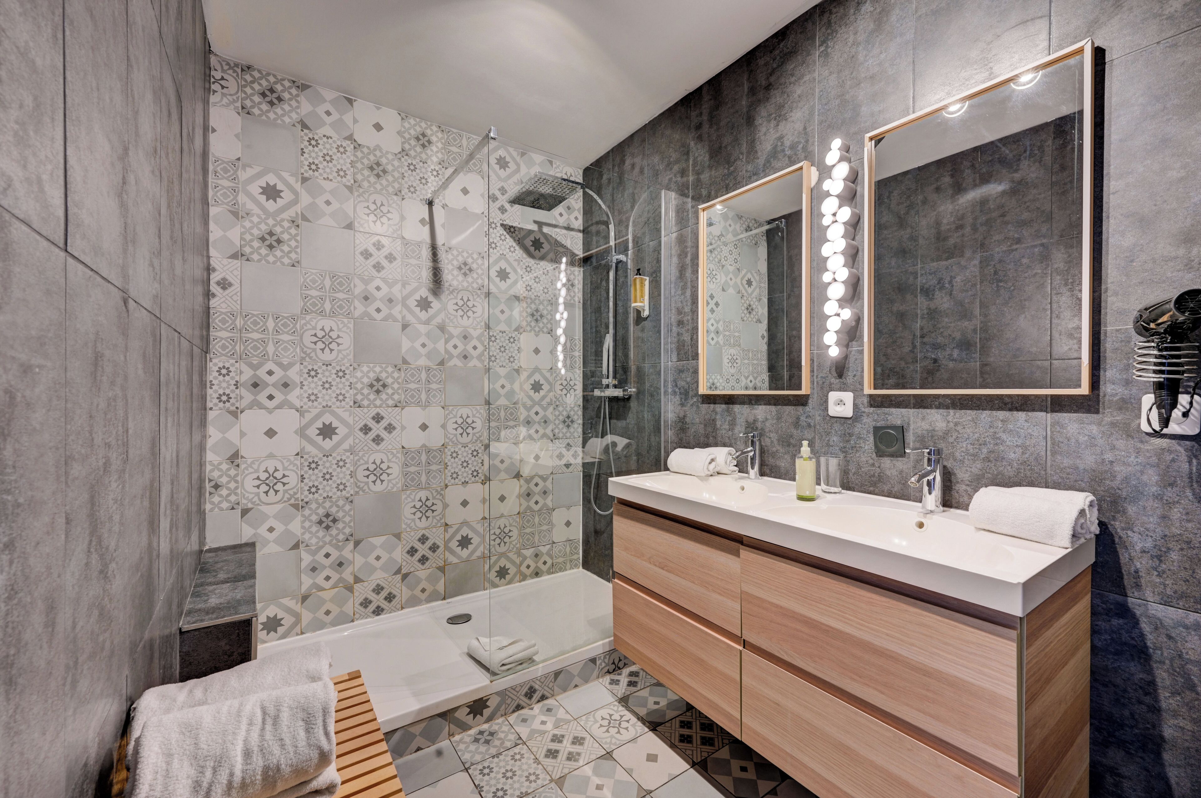 Een moderne badkamer met een douchecabine van glas, een wastafel met spiegel en een bad.
