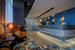 A modern hotel lobby with a reception desk, seating area, and patterned floor tiles. - Urban Loft & Spa Marseille (Marseille)