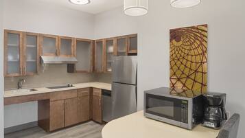 A modern kitchen with wooden cabinets, stainless steel appliances, a microwave, and a coffee maker.