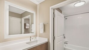 A bathroom with a white vanity, a large mirror, a bathtub, and a shower area. - Staybridge Suites Florence - Civic Center by IHG (Florence)
