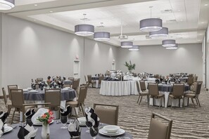 A conference room with round tables, chairs, and a carpeted floor. - Staybridge Suites Florence - Civic Center by IHG (Florence)