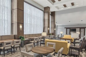 A hotel lobby with a seating area, a television, and a reception desk. - Staybridge Suites Florence - Civic Center by IHG (Florence)
