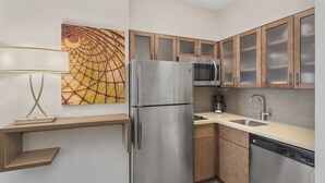 A modern kitchen with stainless steel appliances, wooden cabinets, a microwave, and a dishwasher. - Staybridge Suites Florence - Civic Center by IHG (Florence)