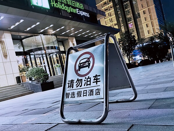 A sign in front of a building with a no parking symbol and text in a foreign language.
