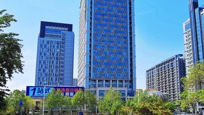 Un edifici alts amb un cartell de Holiday Inn Express, amb una façana de vidre moderna i nombrosos pisos.
