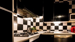 A kitchen with a checkered backsplash, stainless steel appliances, and a dishwasher.