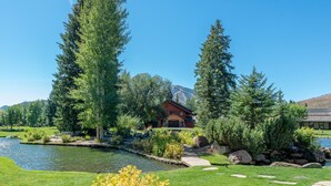 A serene landscape with a pond, lush greenery, and a mountain backdrop. - Bridgepoint Condo 8 - Freshly Updated, Baldy Views, Walk to Downtown & Lifts (Ketchum)