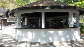 A gazebo-style structure with a curved roof, possibly a small pavilion or kiosk, with a white exterior and a dark roof. - Hotel Camp Karagaq (Pec)
