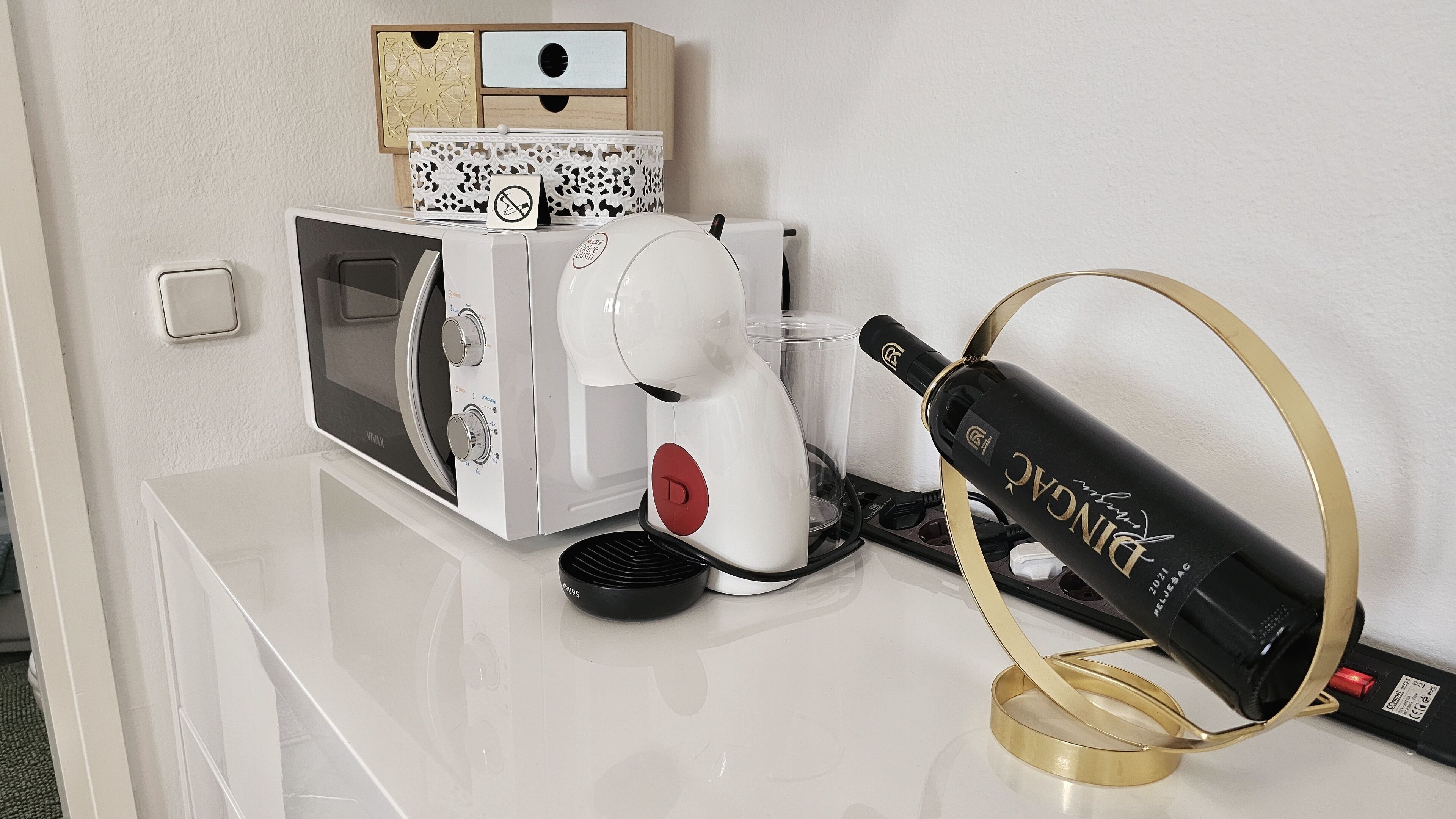 Un coin cuisine équipé d’un four à micro-ondes, d’une machine à café et d’un réfrigérateur à vin.