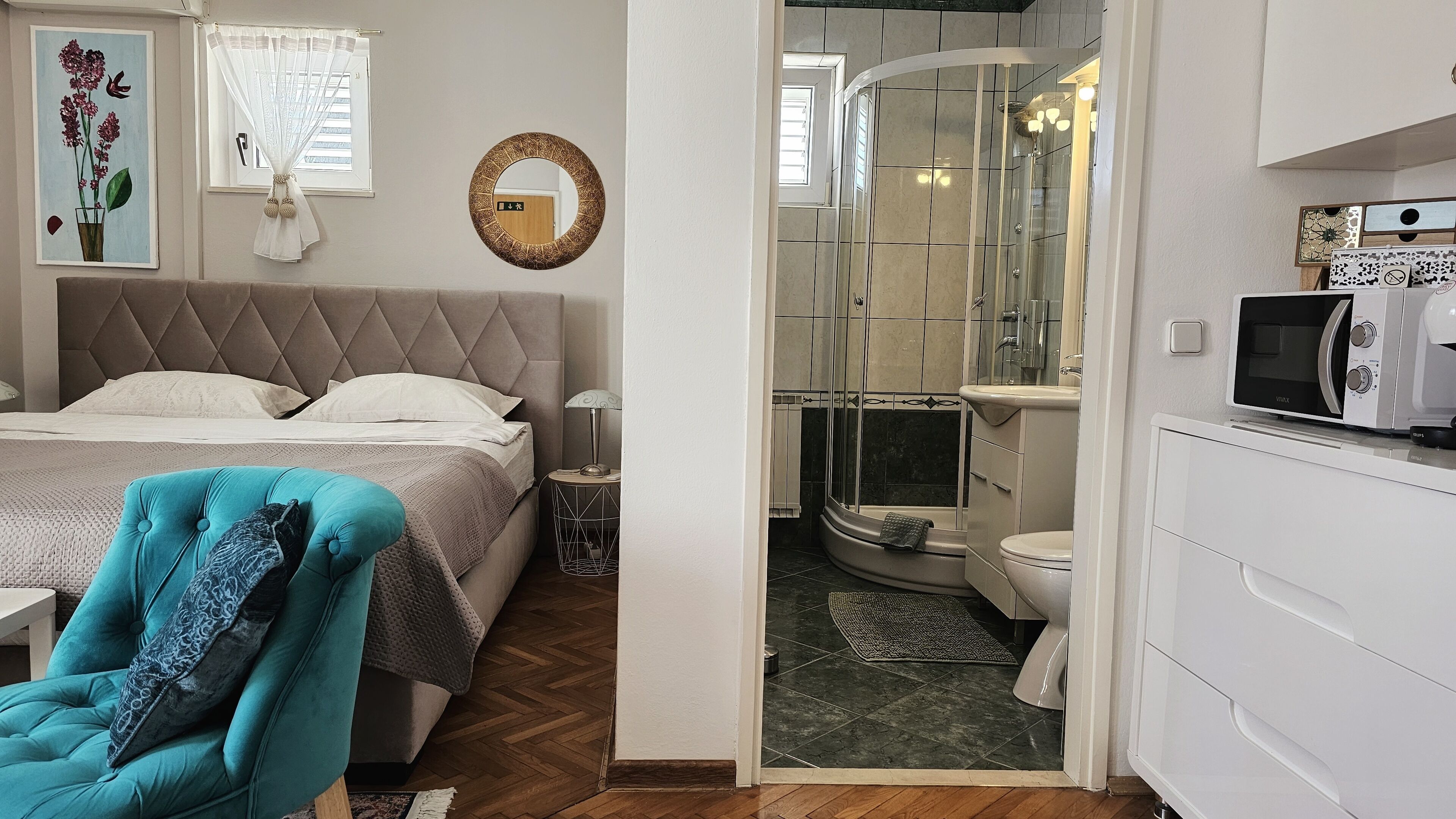 Une chambre à coucher comprenant un lit, une chaise et une salle de bain avec douche, toilettes et lavabo.