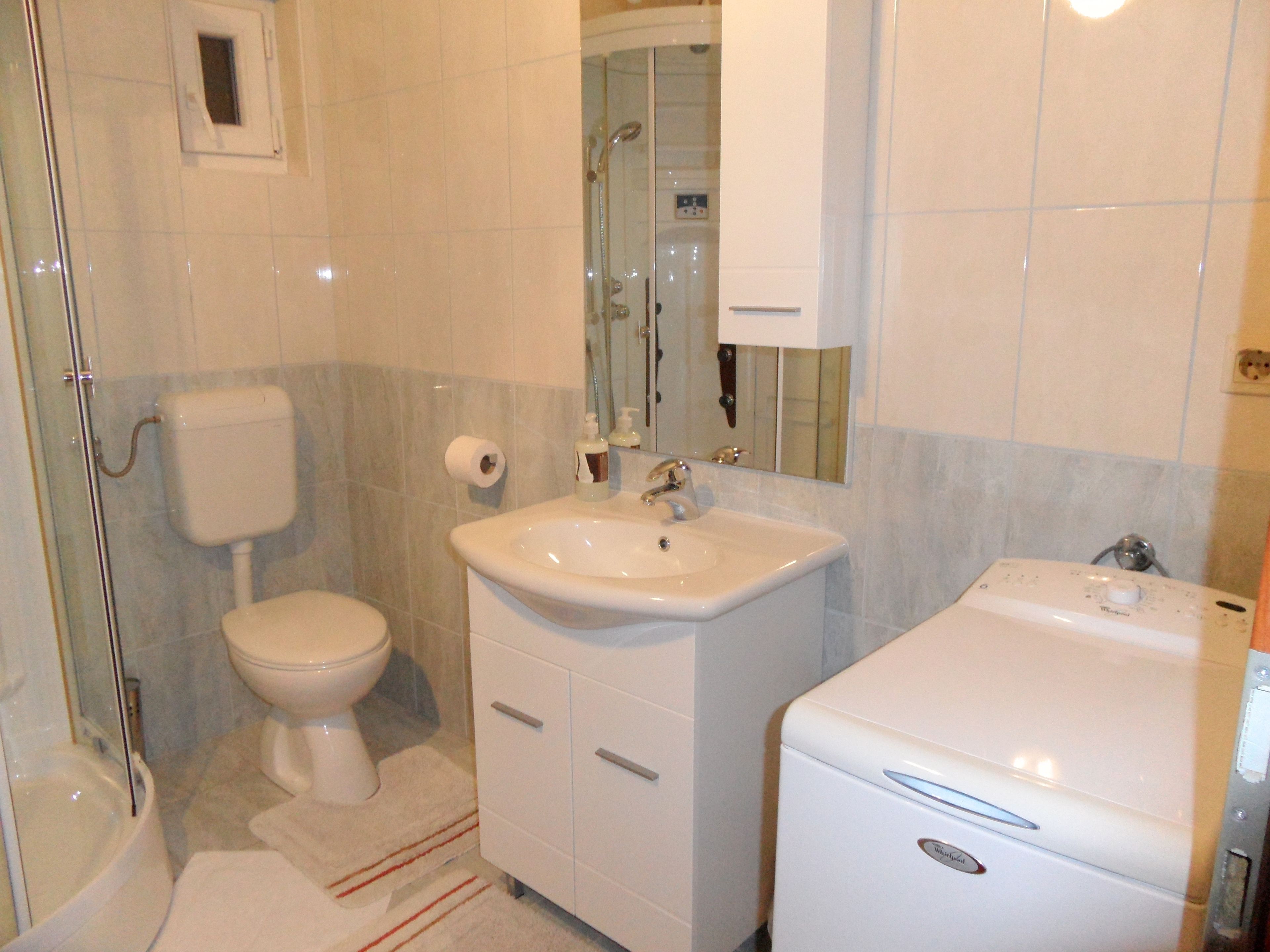 A bathroom with a toilet, sink, and shower.