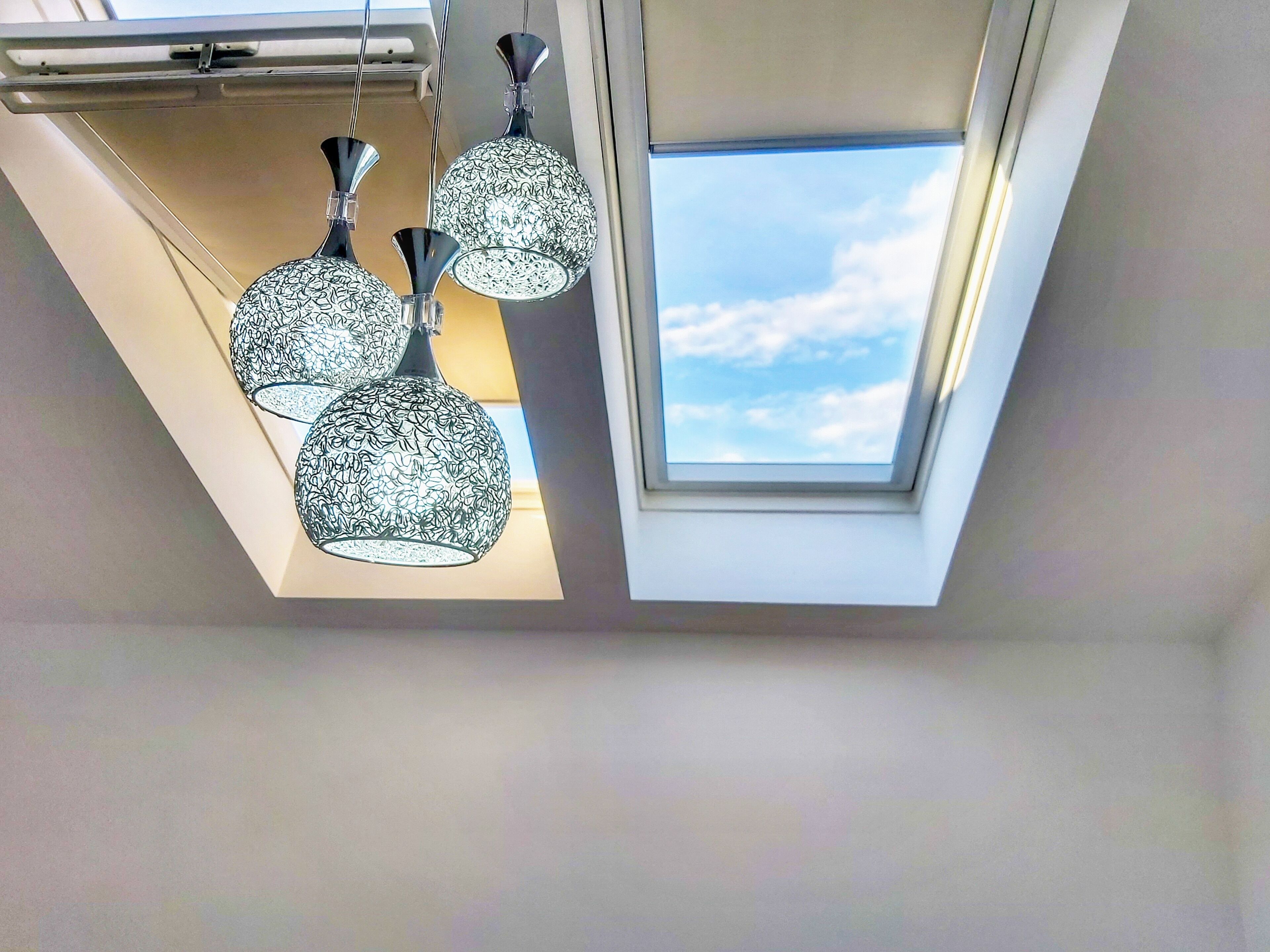 A skylight with three patterned pendant lights hanging below.