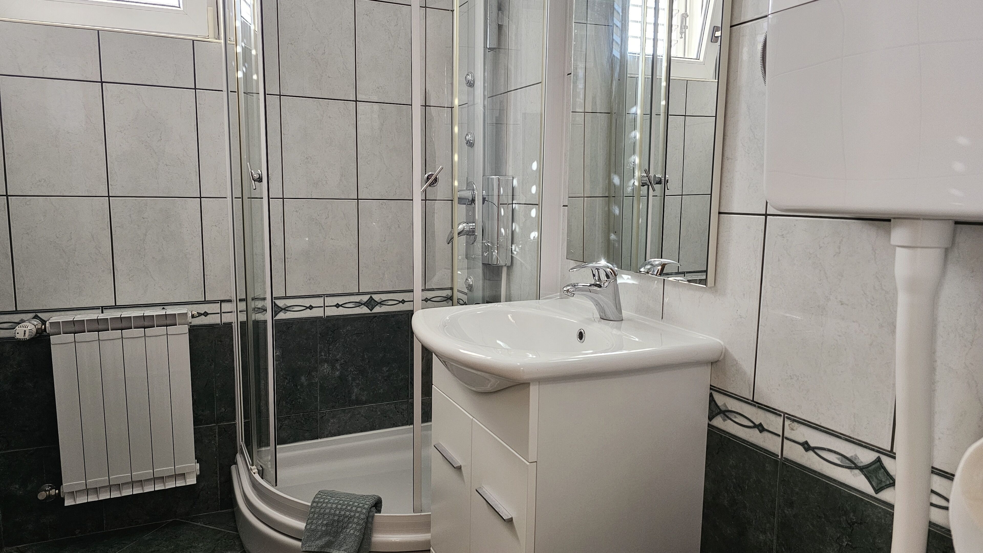 Een badkamer met een bad, douche en wastafel.