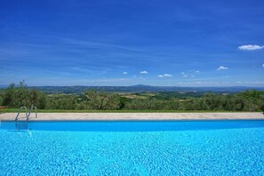 Una piscina con vistas despejadas a un paisaje montañoso al fondo.