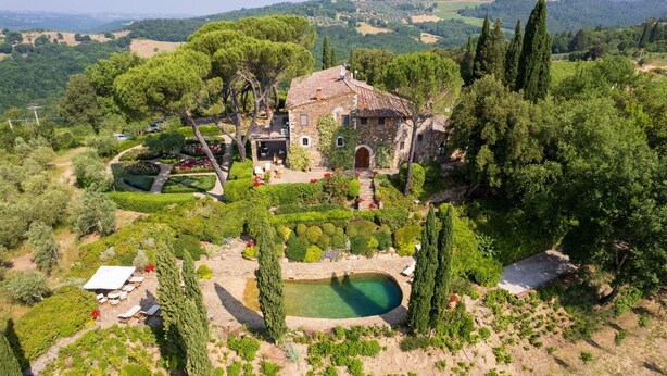 An aerial view of a villa with a garden, a swimming pool, and a stone pathway.